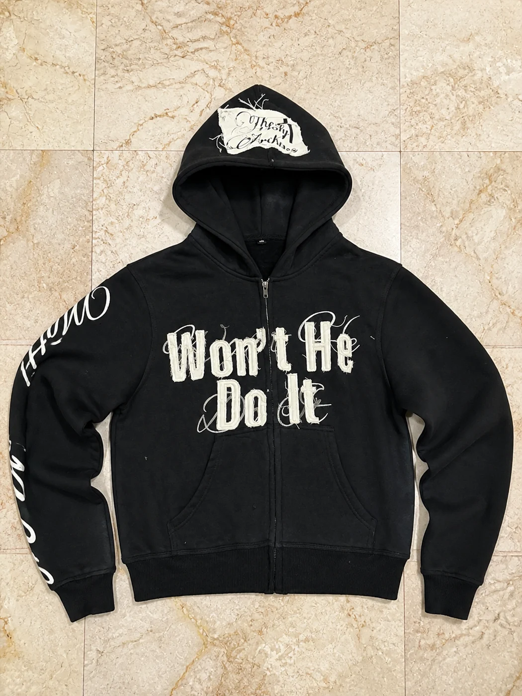 Black zip hoodie with white appliqué lettering and printed sleeve graphics